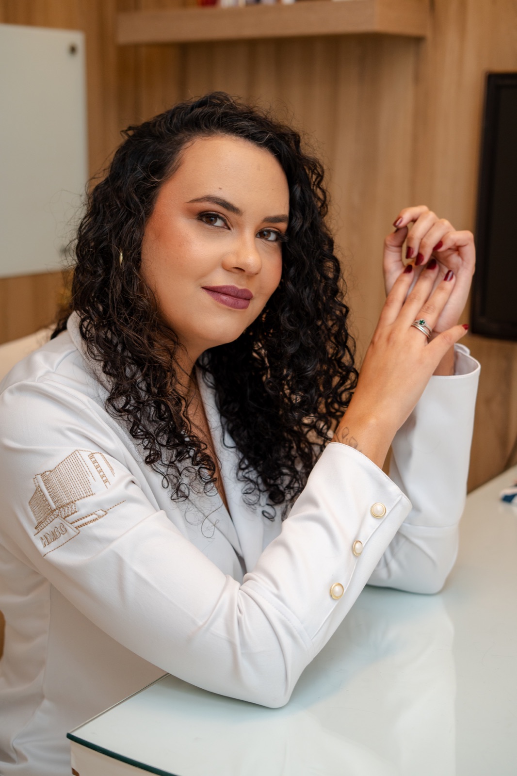Dra. Glaucia Medeiros, ginecologista em Santos, sorrindo em um ambiente de atendimento