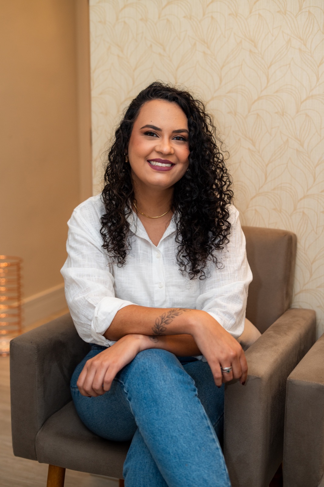 Dra. Glaucia Medeiros, ginecologista em Santos, sentada em uma poltrona