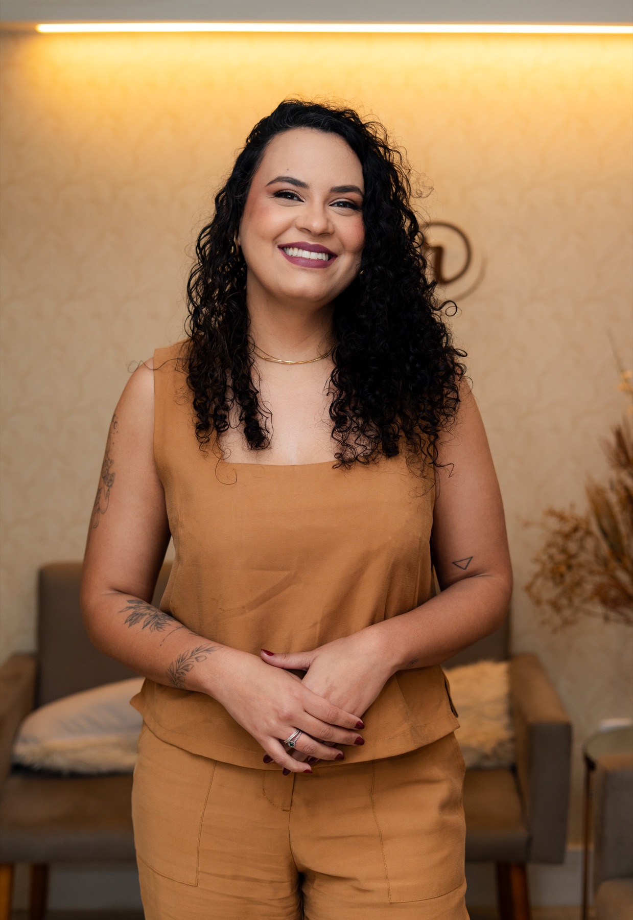 Dra. Glaucia Medeiros, médica ginecologista, sorrindo em um ambiente acolhedor